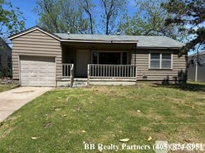 Tulsa apartment for rent - A house with a garage and a porch is for sale.