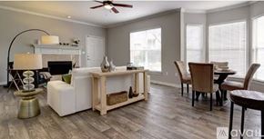 Carrollton apartment for rent - A living room with a white sofa, a wooden coffee table, and a ceiling fan.