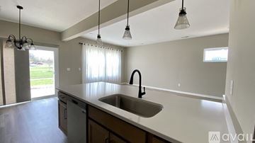 Dayton house for rent - A kitchen with a sink and a window with curtains.