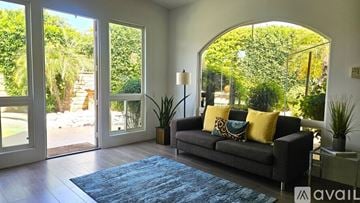 La Quinta house for rent - A living room with a couch and a rug in front of a large window.