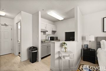 Jeffersonville apartment for rent - A modern kitchen with a white interior and a dining area with a black table and chairs.