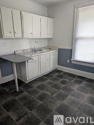 Wilson apartment for rent - A kitchen with white cabinets and a checkered floor.