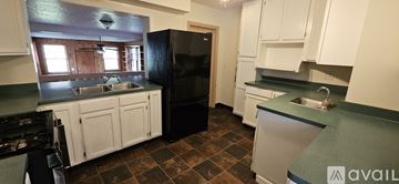 Bloomington house for rent - A kitchen with a black refrigerator and white cabinets.