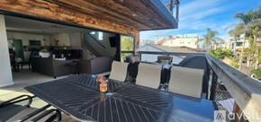 San Diego house for rent - A bedroom with a large bed and a balcony overlooking a street.