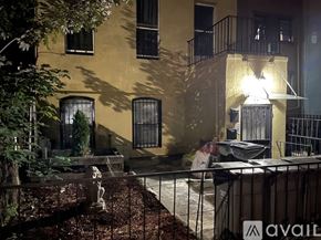 Brooklyn townhouse for rent - A building with a balcony and a garden in front.