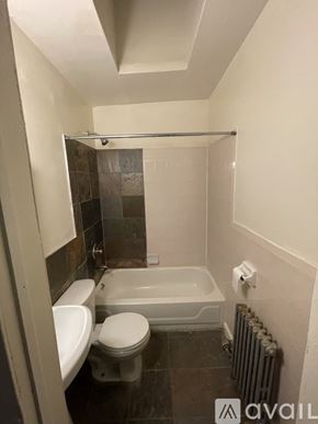 Brooklyn townhouse for rent - A bathroom with a toilet, sink, and bathtub.