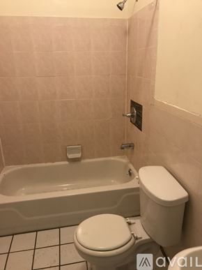 Brooklyn townhouse for rent - A white toilet sits next to a bathtub in a bathroom.