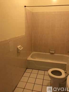 Brooklyn townhouse for rent - A bathroom with a toilet, tub, and tiled floor.
