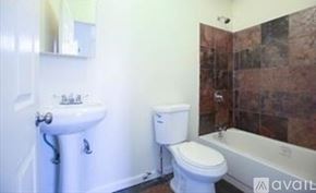Brooklyn townhouse for rent - A bathroom with a toilet, sink, and bathtub.