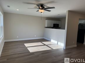 Knoxville townhouse for rent - A spacious room with a ceiling fan and wooden flooring.