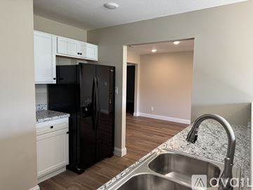 Knoxville townhouse for rent - A kitchen with a black refrigerator and a stainless steel sink.