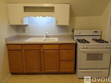 Madison apartment for rent - A kitchen with wooden cabinets and a white stove.
