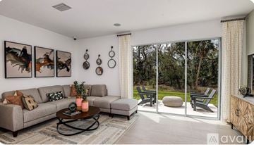 Sarasota townhouse for rent - A living room with a grey couch, a coffee table, and a painting on the wall.