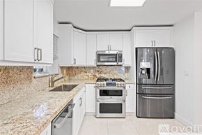 Miami house for rent - A kitchen with granite countertops and stainless steel appliances.
