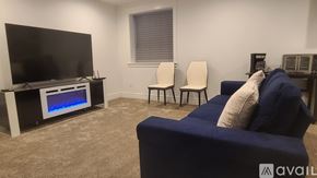Idaho Falls house for rent - A living room with a television, two chairs, and a sofa.