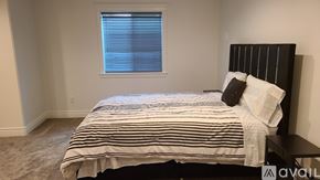 Idaho Falls house for rent - A bedroom with a bed, pillows, and a window with blinds.