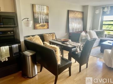 Chicago house for rent - A modern living room with a black sofa and a wooden coffee table.