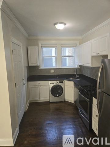 Chicago apartment for rent - A kitchen with white cabinets and a black countertop.