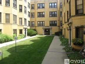 Chicago apartment for rent - A grassy area in front of a building with a sign that says "AVAILABLE".