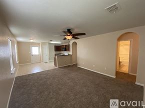 San Antonio house for rent - A spacious living room with a ceiling fan and a kitchenette in the background.