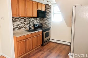 Salem apartment for rent - A kitchen with wooden cabinets and a black microwave above the stove.