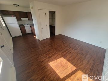 La Crosse apartment for rent - A room with wooden flooring and a kitchen area in the background.