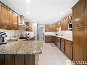 Broken Arrow house for rent - A kitchen with wooden cabinets and granite countertops.