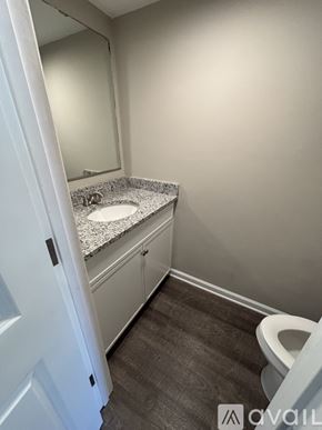 St. Simons Island apartment for rent - A bathroom with a toilet, sink, and mirror.