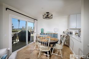 Oceanside apartment for rent - A dining room with a table set for two and a view of the outside.