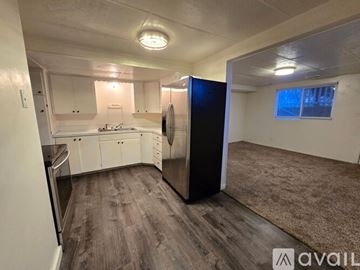 Bountiful house for rent - A kitchen with white cabinets and a black refrigerator.