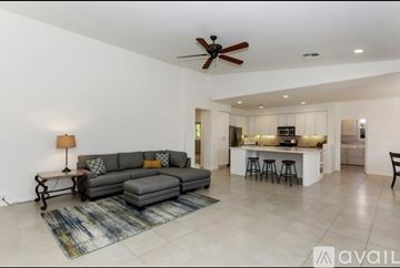 La Quinta house for rent - A living room with a grey couch and a ceiling fan.