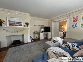 Boston apartment for rent - A living room with a fireplace and a grey sofa.