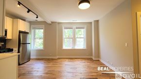 Chicago apartment for rent - A room with wooden floors and a window with blinds.