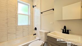Chicago apartment for rent - A spacious room with wooden floors and a window.