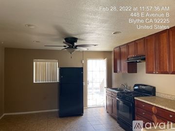 Blythe house for rent - A kitchen with a black fridge, black stove, and a ceiling fan.