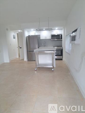 Surfside apartment for rent - A kitchen with a stainless steel refrigerator, microwave, and oven.