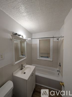 East Cleveland apartment for rent - A hallway with a white door and a vacuum cleaner in the background.