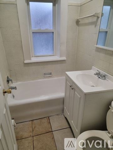 East Cleveland apartment for rent - A kitchen with a white refrigerator, black stove, and a sink.