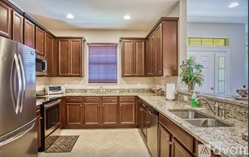 Fort Myers house for rent - A kitchen with brown cabinets and a stainless steel refrigerator.