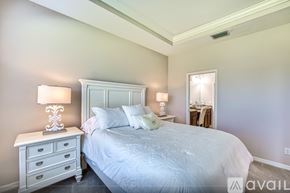Fort Myers house for rent - A bedroom with a large bed and two lamps.