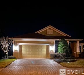 Brooksville house for rent - A house with a garage and driveway is lit up at night.