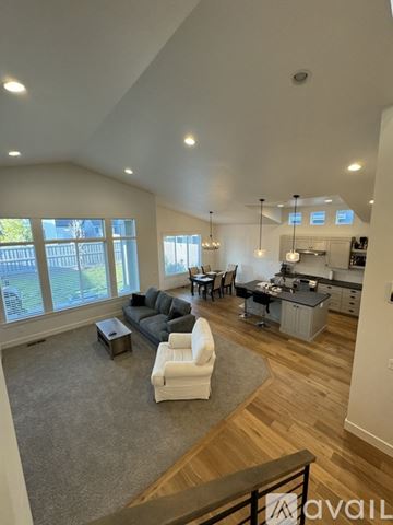 Nampa house for rent - A spacious living room with a grey sofa and a white armchair.