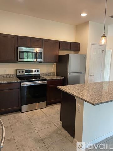 Punta Gorda apartment for rent - A kitchen with brown cabinets and a granite countertop.