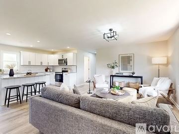 Mt. Juliet house for rent - A modern living room with a grey sofa and a kitchen area in the background.