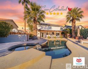 Cathedral City house for rent - A house with a pool and palm trees in front of it.