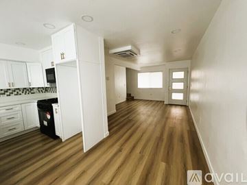 Westminster apartment for rent - A kitchen with white cabinets and a black trash bin.