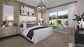 Indian Wells apartment for rent - A modern bedroom with a large bed, a chandelier, and a view of the backyard through the sliding glass doors.