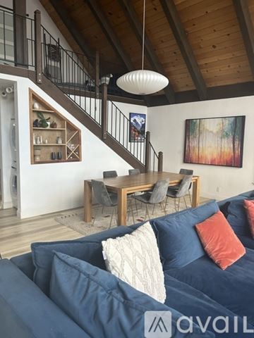 South Lake Tahoe apartment for rent - A living room with a blue couch and a wooden staircase.