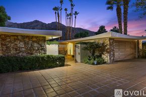 Indian Wells apartment for rent - A house with a driveway and palm trees in the background.