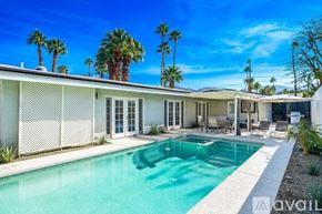 Palm Desert house for rent - A pool in front of a house with palm trees in the background.